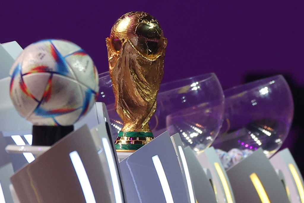 كأس العالم وكرة "الرحلة" المخصصة لمونديال قطر 2022 خلال قرعة المجموعات في الدوحة في الأول من نيسان/أبريل 2022(ا ف ب)
