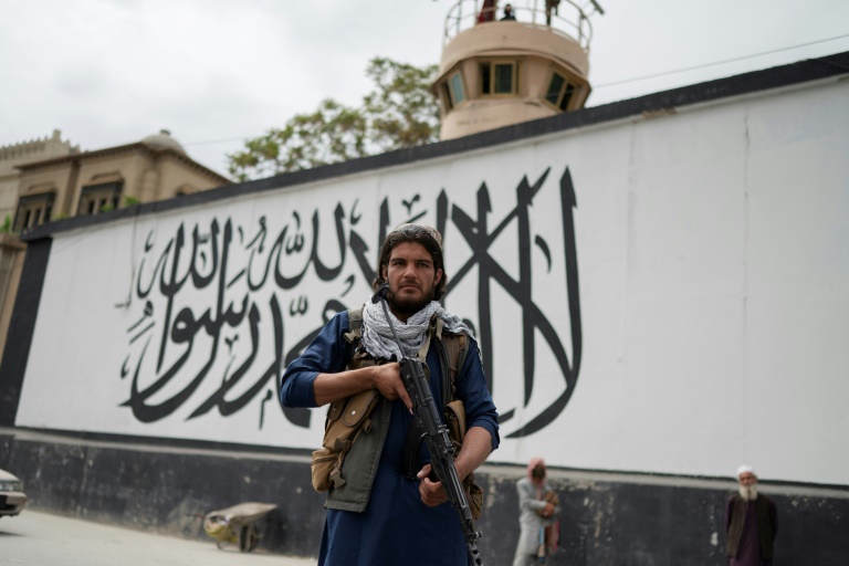   مقاتل من طالبان يقف حارسا بالقرب من احتجاج لأفغان يشكون من معاملة اللاجئين في إيران (برس)
