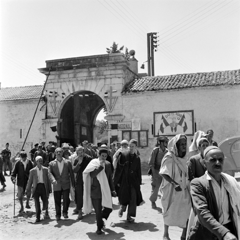 جزائريون يسيرون بالقرب من Porte d'Alger في 2 يوليو 1958 في Fort National في منطقة القبائل ، موطن الأجداد لكريستوف ساند المنحدر من سلالة جزائريين تم ترحيلهم إلى كاليدونيا الجديدة (ا ف ب)