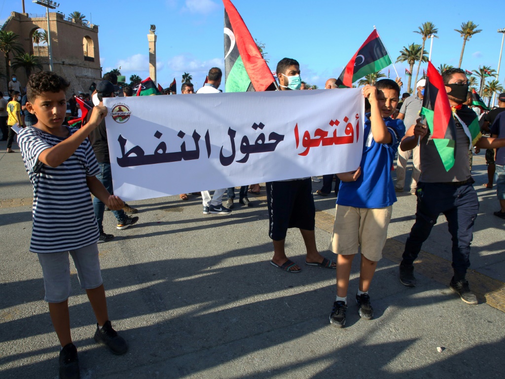 ليبيون يحملون لافتة تطالب بفتح حقول النفط خلال تظاهرة في طرابلس بتاريخ 25 آب/اغسطس 2020(ا ف ب)