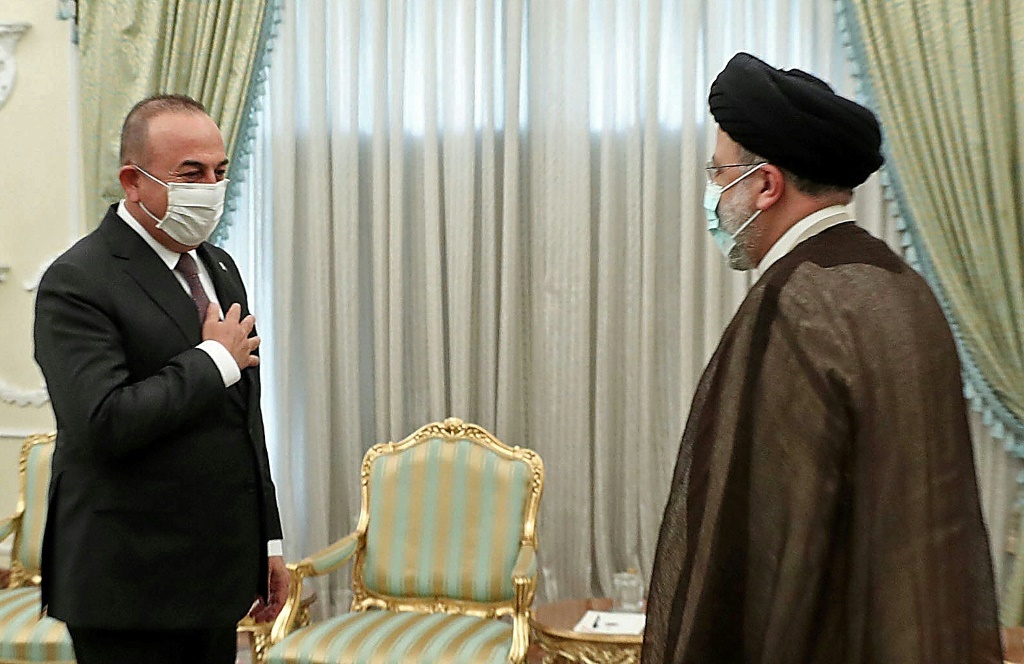  الرئيس الإيراني إبراهيم رئيسي مستقبلا وزير الخارجية التركي مولود تشاوش أوغلو في طهران في 15نوفمبر 2021 (أ ف ب)