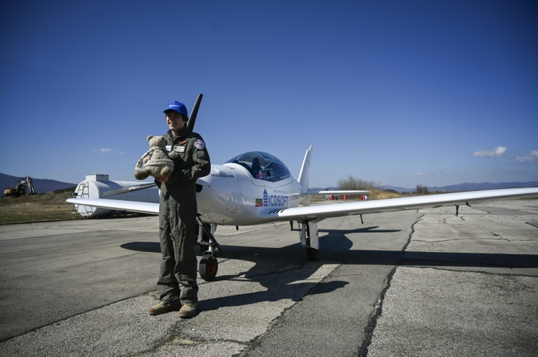 ماك روثرفورد يحمل دبا قماشيا قبل بدء جولة حول العالم على طائرة فائقة الخفة في مطار قرب مدينة رادومير البلغارية في 23 آذار/مارس 2022 (ا ف ب)