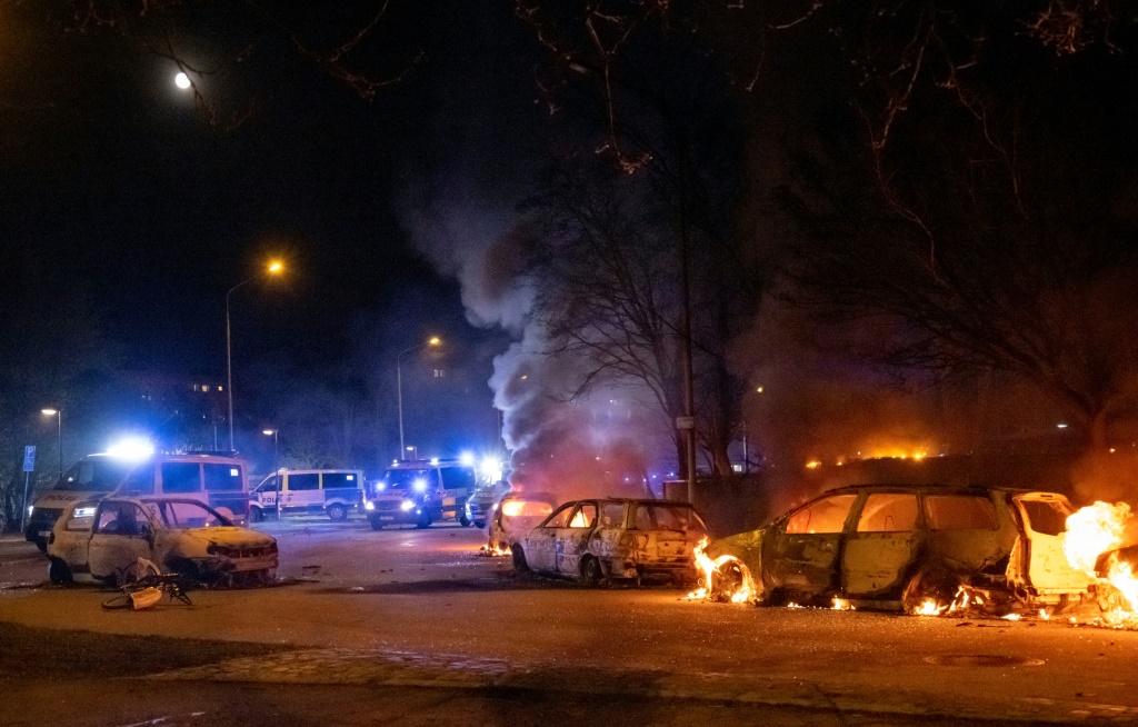 صور سيارات محترقة في 18 نيسان/أبريل 2022 بالقرب من روزنغارد في مالمو. أثارت خطط مجموعة يمينية متطرفة لحرق نسخ من المصحف صدامات عنيفة مع متظاهرين مناهضين لها (اف ب)
