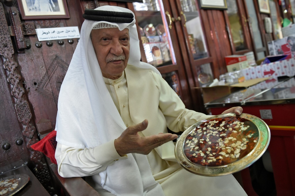 محمد غريب يخمل في 18 نيسان/أبريل 2022 في المنامة طبقاً من الحلوى البحرينية التقليدية (اف ب)