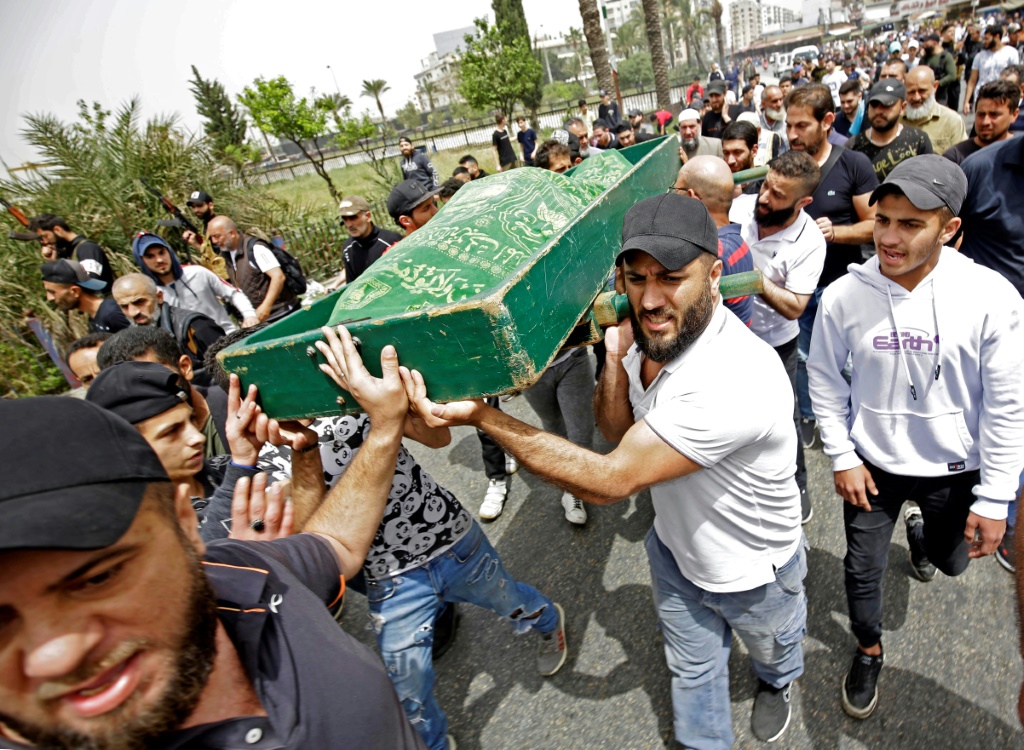 مشيعون يحملون جثة ضحية بعد انقلاب قارب محمّل بالمهاجرين قبالة مدينة طرابلس الشمالية ، في جنازة يوم 25 أبريل 2022 (أ ف ب)