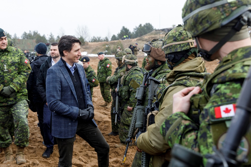 رئيس الوزراء الكندي جاستن ترودو يتحدث مع الجنود خلال زيارة لقاعدة أدازي العسكرية ، شمال شرق ريغا ، لاتفيا ، في مارس 2022 (أ ف ب)