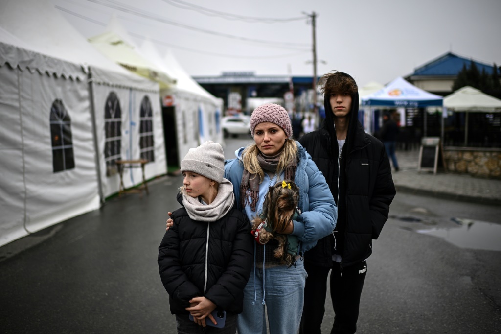 الفرار مرة أخرى: اللاجئة الأوكرانية إيرينا أوستيانسكا ، 38 عامًا ، مع طفليها أولينا (على اليسار) ودانيلو بعد عبور الحدود الأوكرانية الرومانية (أ ف ب)