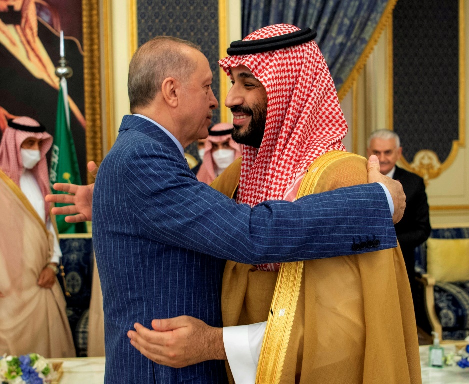 الرئيس التركي رجب طيب أردوغان (إلى اليسار) يحتضن ولي العهد السعودي الأمير محمد بن سلمان خلال لقائهما في جدة (أ ف ب)