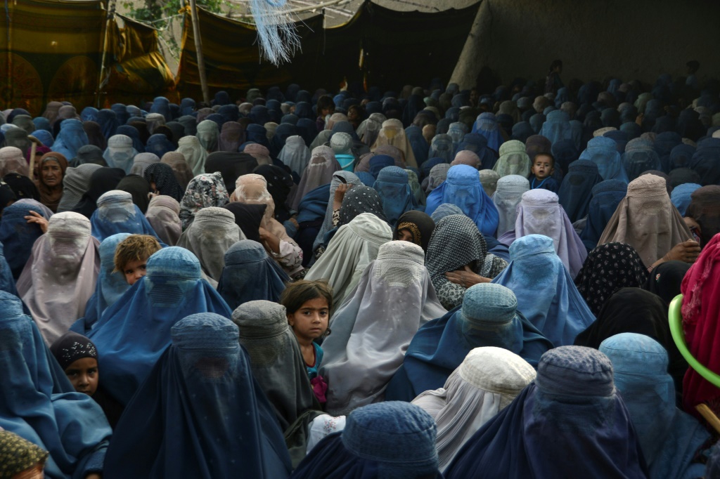 نساء وأطفالهن ينتظرن تلقي مساعدات غذائية في قندهار بتاريخ 27 نيسان/أبريل 2022 (أ ف ب)