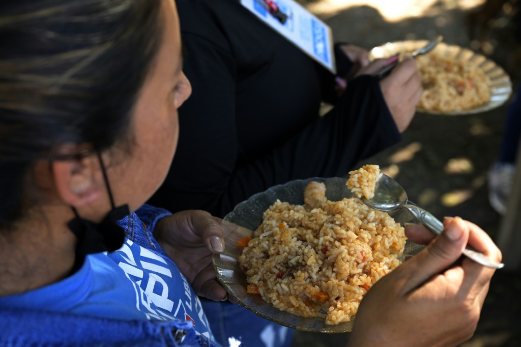 متطوعة تأكل وجبة في مطبخ شعبي في حي بيلين دي إسكوبار قرب بوينس أيريس، في 21 نيسان/أبريل 2022 (ا ف ب)