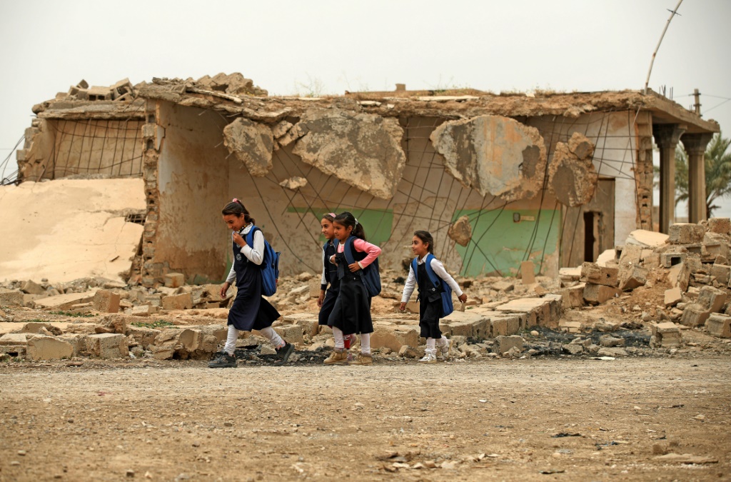 أطفال يلعبون في مبنى مدمر في بلدة حبش في شمال العراق في 25 نيسان/أبريل 2022 (ا ف ب)