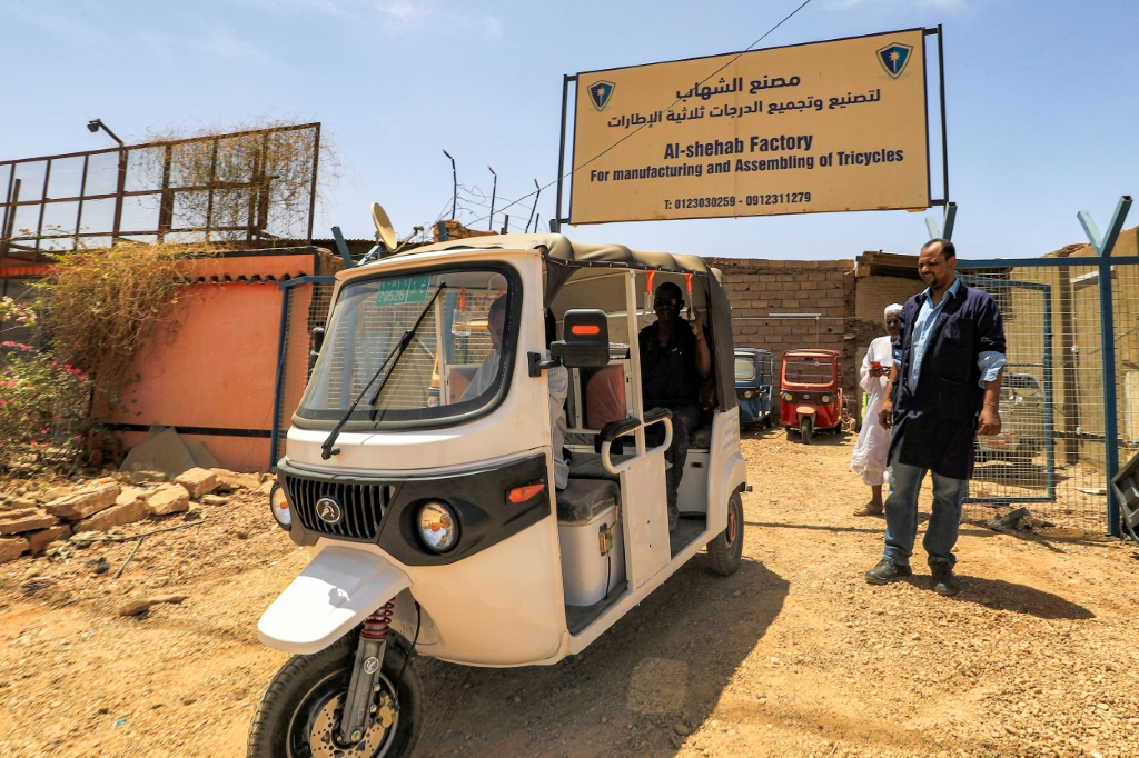 صورة التقطت في 19 نيسان/أبريل 2022 لعامل يتولى تجميع عربة توك توك كهربائية في معمل الشهاب بحي الخرطوم بحري في العاصمة السودانية(اف ب)