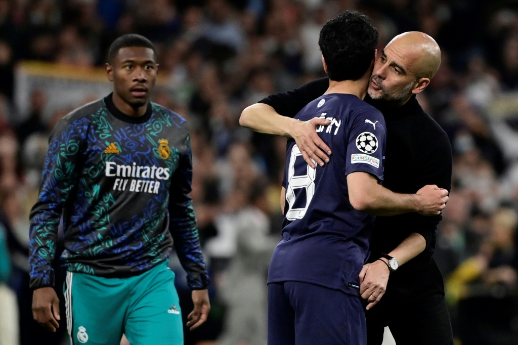 المدرب الاسباني لمانشستر سيتي الانكليزي بيب غوارديولا يواسي لاعب وسطه الالماني إيلكاي غوندوغان عقب الخسارة امام ريال مدريد 1-3 بعد التمديد في اياب نصف نهائي مسابقة دوري أبطال أوروبا في الرابع من أيار/مايو 2022 (ا ف ب)