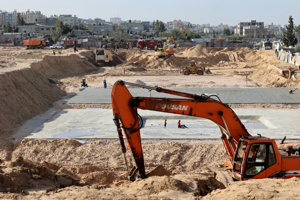 حفارون مصريون وعمال تربة يعملون في موقع بناء مجمع سكني جديد شمال مدينة غزة. قدمت مصر وقطر مساعدات لإعادة إعمار غزة (أ ف ب)