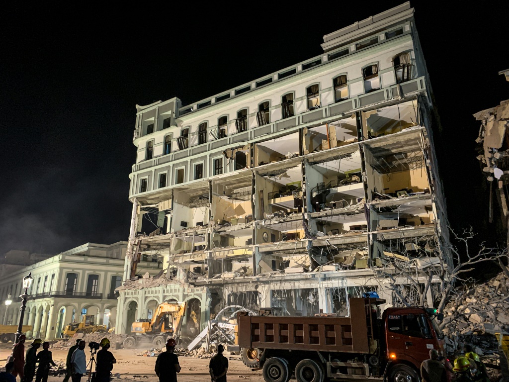رجال إطفاء يبحثون بين أنقاض فندق ساراتوغا في العاصمة الكوبية هافانا بعد انفجار دمره في 6 أيار/مايو 2022 (ا ف ب)