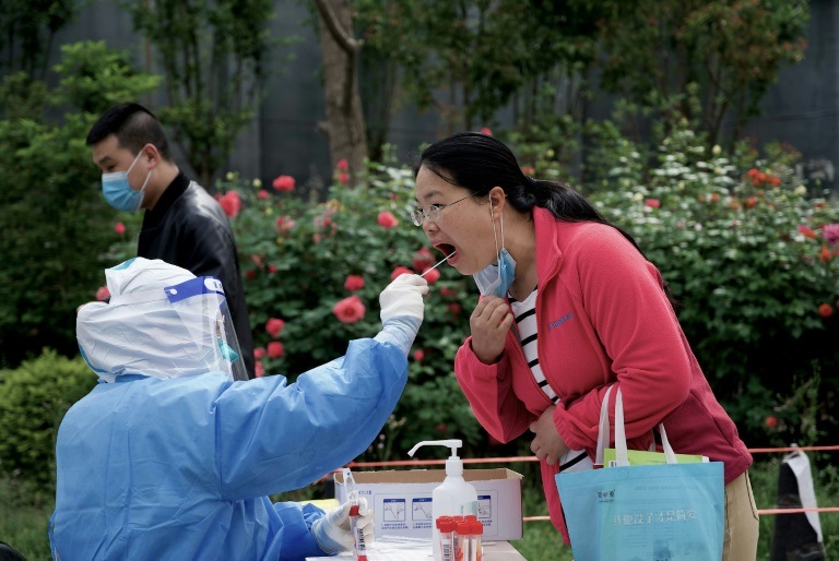 عاملة صحية تجري فحص كوفيد لامرأة في بكين في 9 أيار/مايو 2022 (ا ف ب)
