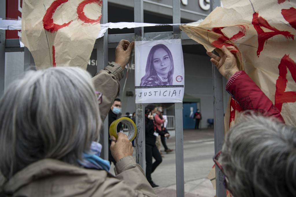 نساء يرفعن صورة الصحافية فرنسيسكا ساندوفال أمام مستشفى في العاصمة التشيلية سانتياغو بعد إعلان وفاتها في 12 أيار/مايو 2022 (اف ب)