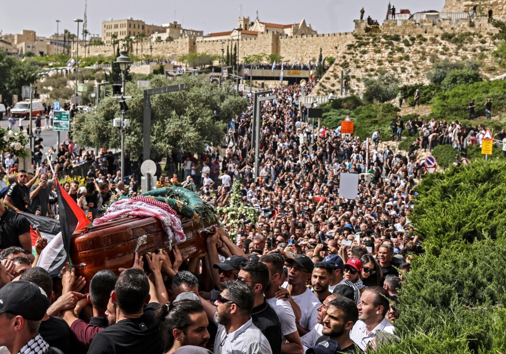 مشيعون فلسطينيون يحملون نعش الصحافية شيرين أبو عاقلة من الكنيسة إلى المقبرة خلال موكب جنازتها في القدس في 13 أيار/مايو 2022 (اف ب)