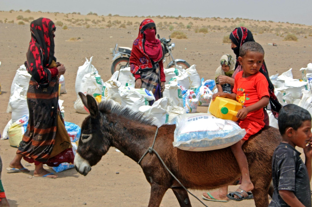 عائلات يمنية تنقل مساعدات من منظمة خيرية في محافظة لحج في جنوب اليمن في 29 آذار/مارس 2022 (أ ف ب)  