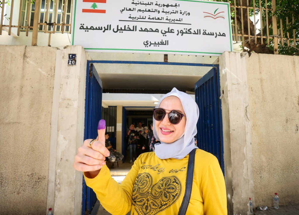 امرأة لبنانية تظهر إبهامها الملطخ بالحبر بعد الإدلاء بصوتها في الانتخابات البرلمانية يوم الأحد (أ ف ب)