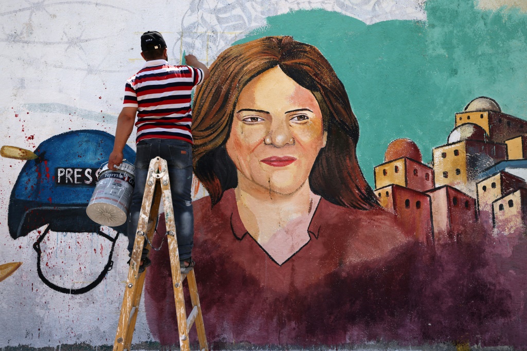 فنان يرسم صورة للصحافية الفلسطينية الراحلة شيرين ابو عاقلة في غزة في 12 أيار/مايو 2022 (اف ب)
