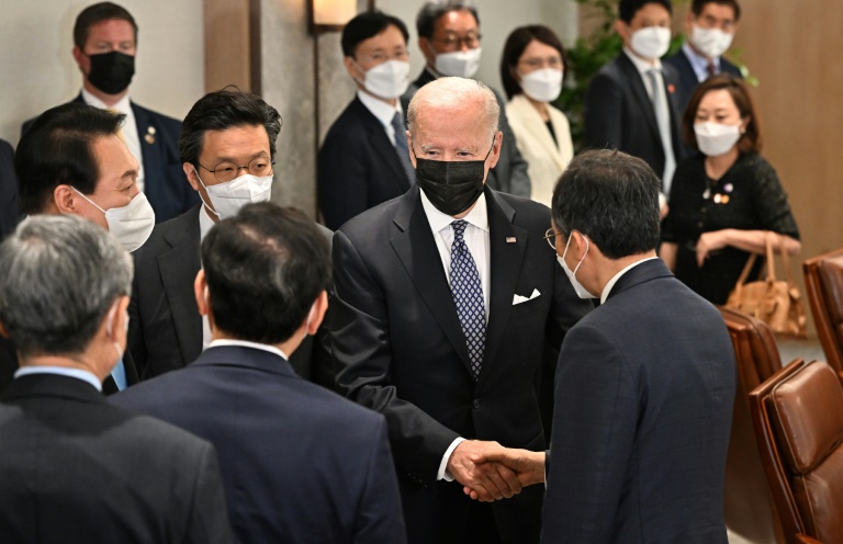 الرئيس الأميركي جو بايدن (وسط) يصافح مسؤولا كوريا جنوبيا قبل لقاء مع الرئيس الكوري الشمالي يون سوك يول في المقر الرئاسي في سيول في 21 أيار/مايو 2022 (ا ف ب)