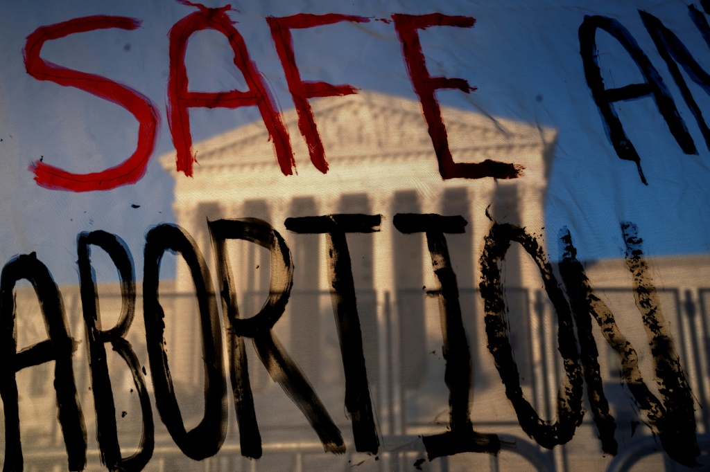مقر المحكمة الأميركية العليا في واشنطن وقد بدا من خلال لافتة تدعو إلى حماية الحقّ في الإجهاض في 10 أيار/مايو 2022 (ا ف ب).
