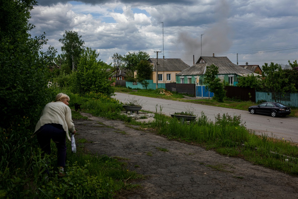 امرأة تحتمي من القصف في قرية طٌردت منها القوات الروسية مؤخرًا قرب خاركيف في أوكرانيا في 25 أيار/مايو 2022 (أ ف ب)