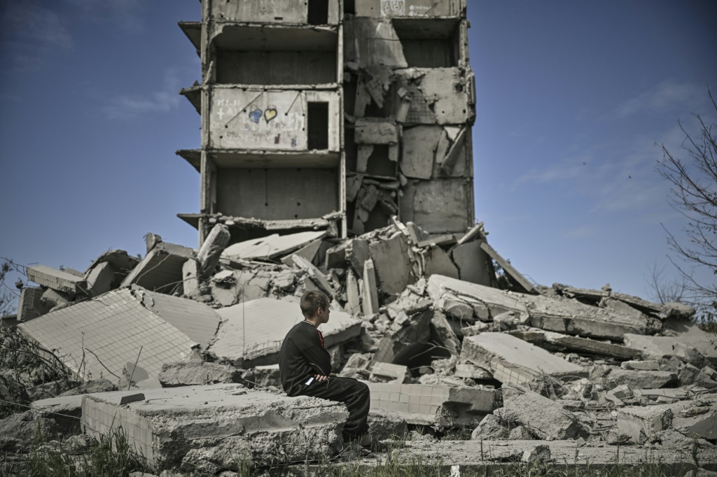 فتى يجلس أمام مبنى مدمّر بعد ضربة جوية في كراماتورسك في منطقة دونباس في شرق أوكرانيا في 25 أيار/مايو 2022 (أ ف ب)