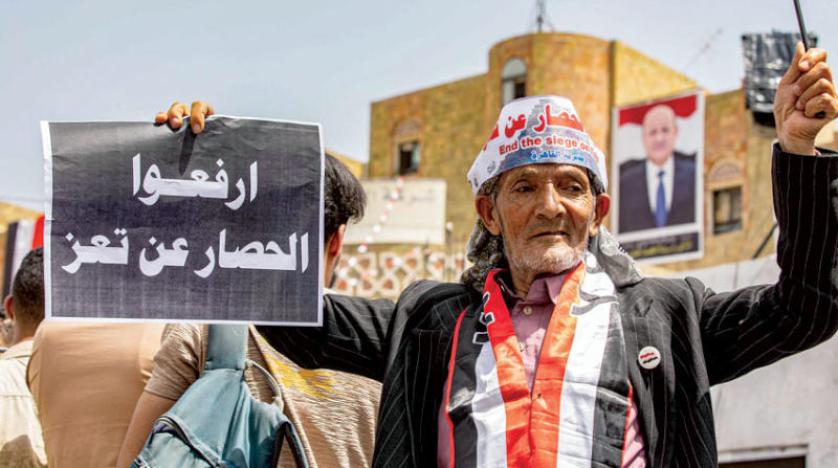 متظاهر يحمل لافتة ضمن حشود خرجت تنادي برفع حصار تعز الأربعاء (أ.ف.ب)