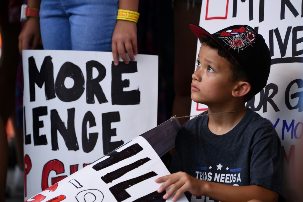 طفل يحمل لافتة ويشارك في احتجاج خارج الاجتماع السنوي لجمعية البندقية الوطني في هيوستن في تكساس في 27 أيار/مايو 2022 (ا ف ب)