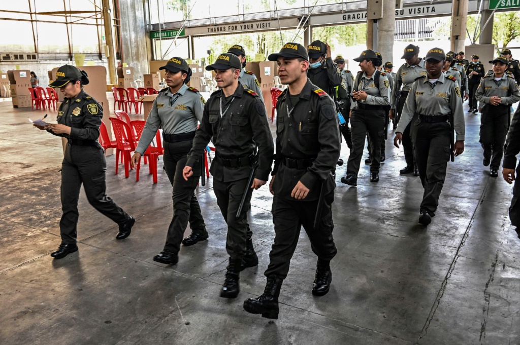 عناصر من الشرطة يدخلون إلى مركز اقتراع في ميديين بشمال غرب كولومبيا للإشراف على الانتخابات الرئاسية في 28 أيار/مايو 2022 (ا ف ب)