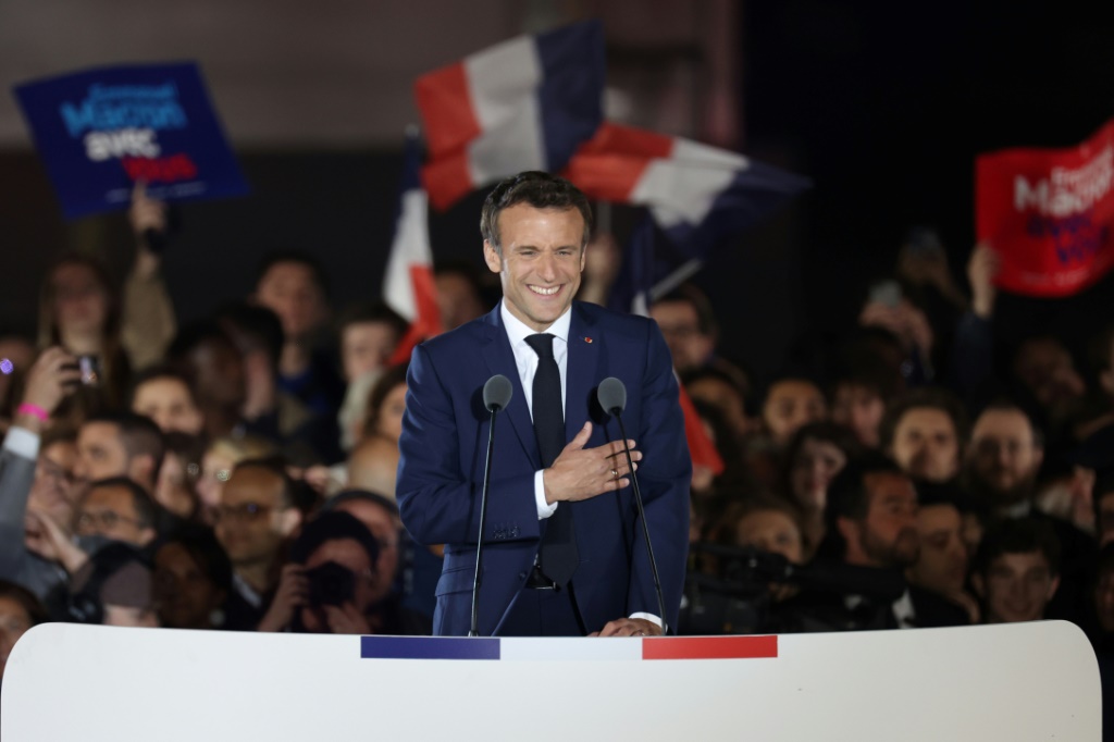 الرئيس الفرنسي إيمانويل ماكرون محتفلًا بفوزه في الانتخابات وسط تجمّع أنصاره في حديقة "شان دو مارس" في باريس في 24 نيسان/أبريل 2022 (أ ف ب)
