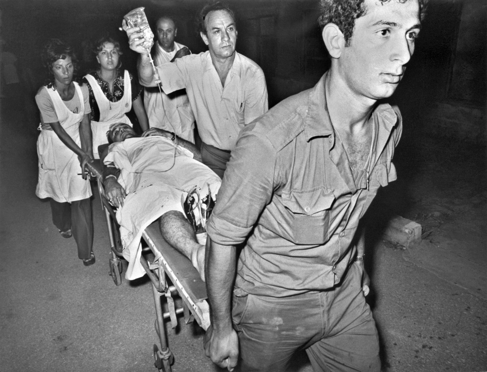 في هذه الصورة التي تم التقاطها في 30 مايو ، 1972 ، المسعفون الإسرائيليون يخلون جريحًا على نقالة بعد هجوم بالمدافع الرشاشة والقنابل اليدوية على مطار اللد (أ ف ب)