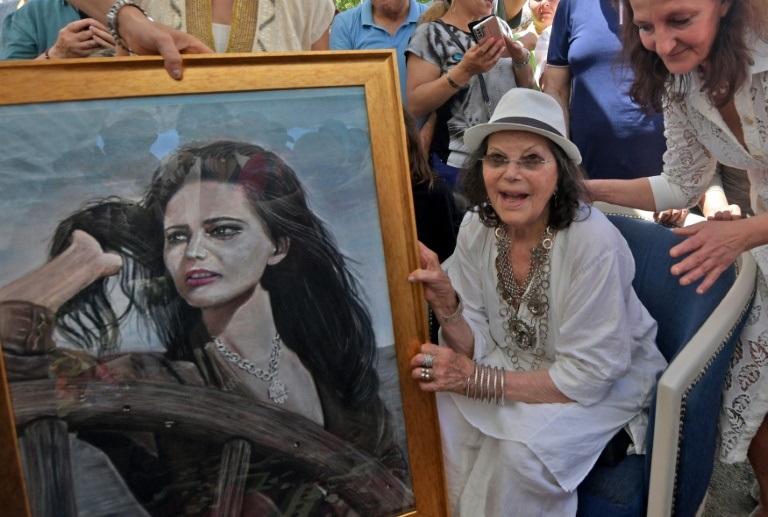 الممثلة الإيطالية التونسية كلوديا كاردينالي بجانب رسم عنها خلال تدشينها شارعا يحمل اسمها في مدينة حلق الوادي قرب تونس العاصمة في 29 أيار/مايو 2022 (ا ف ب)