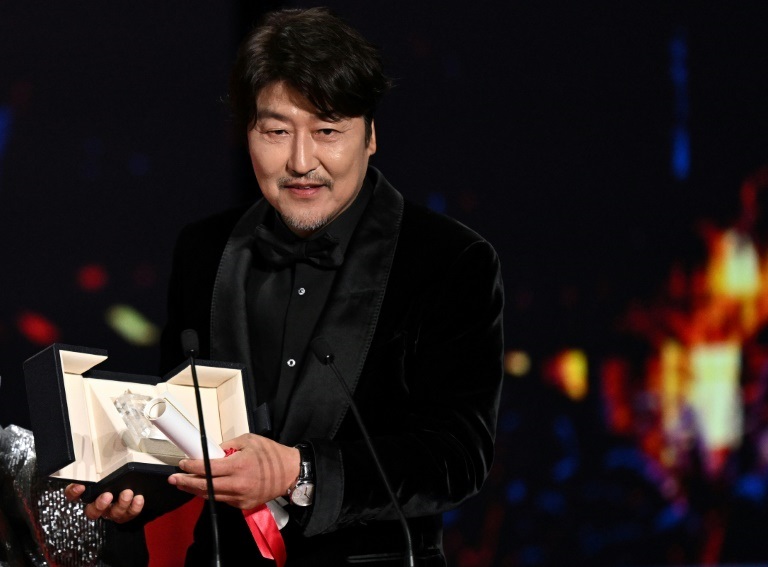 الممثل الكوري الجنوبي سونغ كانغ هو يحمل درع الفوز بجائزة أفضل ممثل في مهرجان كان السينمائي في 28 أيار/مايو 2022 (ا ف ب)