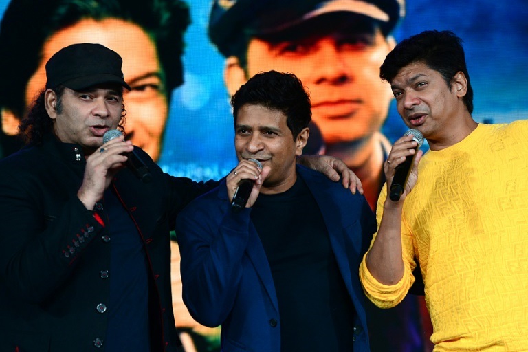 كريشناكومار كوناث يتوسط المغنيين موهيت شوهان (يسار) وشان (يمين) خلال حفلة موسيقية في مومباي 27 أيلول/سبتمبر 2021 (ا ف ب)