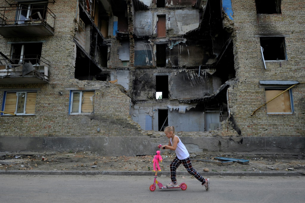 فتاة أمام مبنى مدمر في قرية هورنكا قرب كييف في 4 حزيران/يونيو 2022 (ا ف ب)