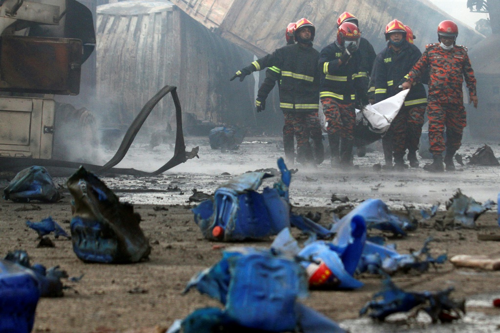نقل جثة أحد ضحايا الحريق في مستودع المستوعبات في سيتاكوندا في 5 حزيران/يونيو 2022 (ا ف ب)