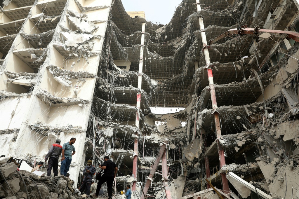الإيرانيون يتجمعون في 24 مايو 2022 في الموقع الذي انهار فيه مبنى من 10 طوابق في اليوم السابق ، في مدينة عبدان جنوب غرب البلاد (ا ف ب)
