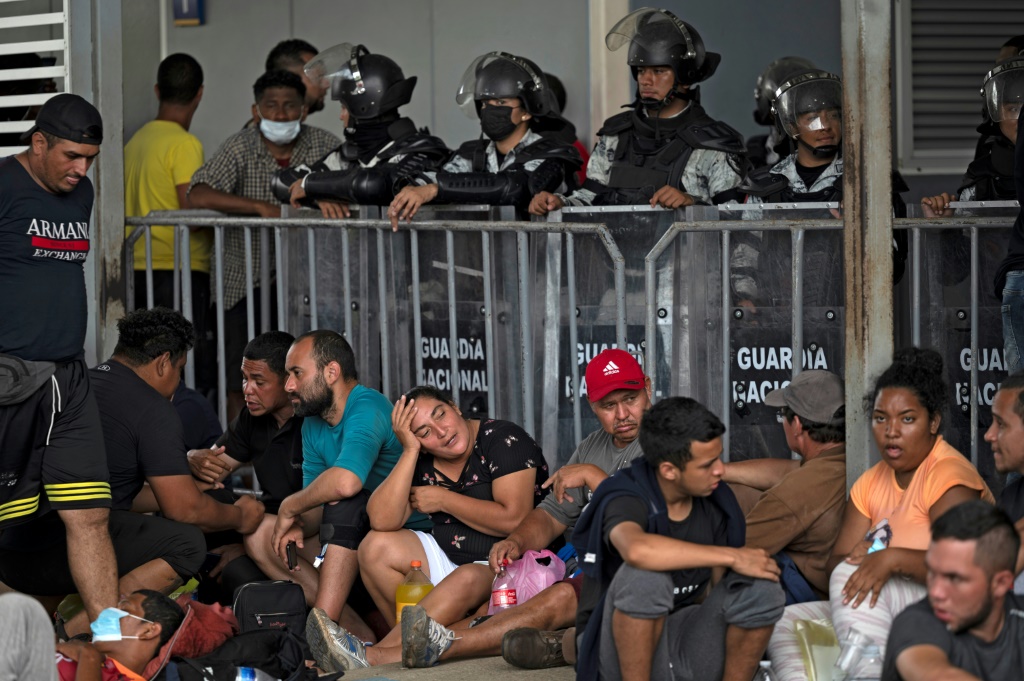 مهاجرون يشاركون في قافلة متوجهة إلى الولايات المتحدة ، ينتظرون تأشيرات العبور خارج مكتب الهجرة في هويكستلا ، المكسيك ، في 8 يونيو 2022 (ا ف ب)   