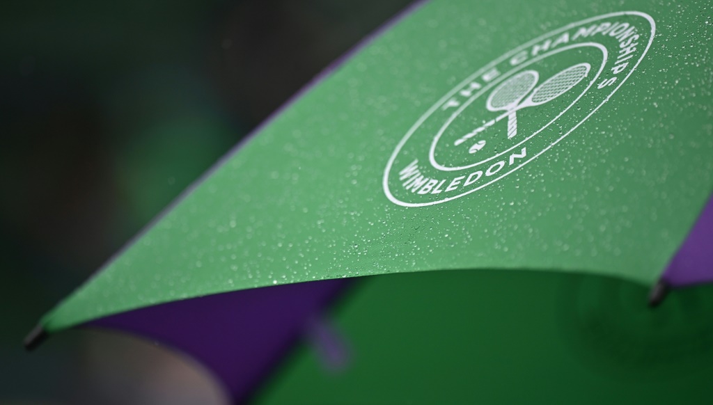 مظلة بطولة ويمبلدون مغطاة بقطرات المطر حيث يختبئ المتفرجون في الملعب رقم 2 خلال اليوم الثاني من بطولة ويمبلدون العام الماضي في غرب لندن في 29 حزيران/يونيو 2021 (ا ف ب)
