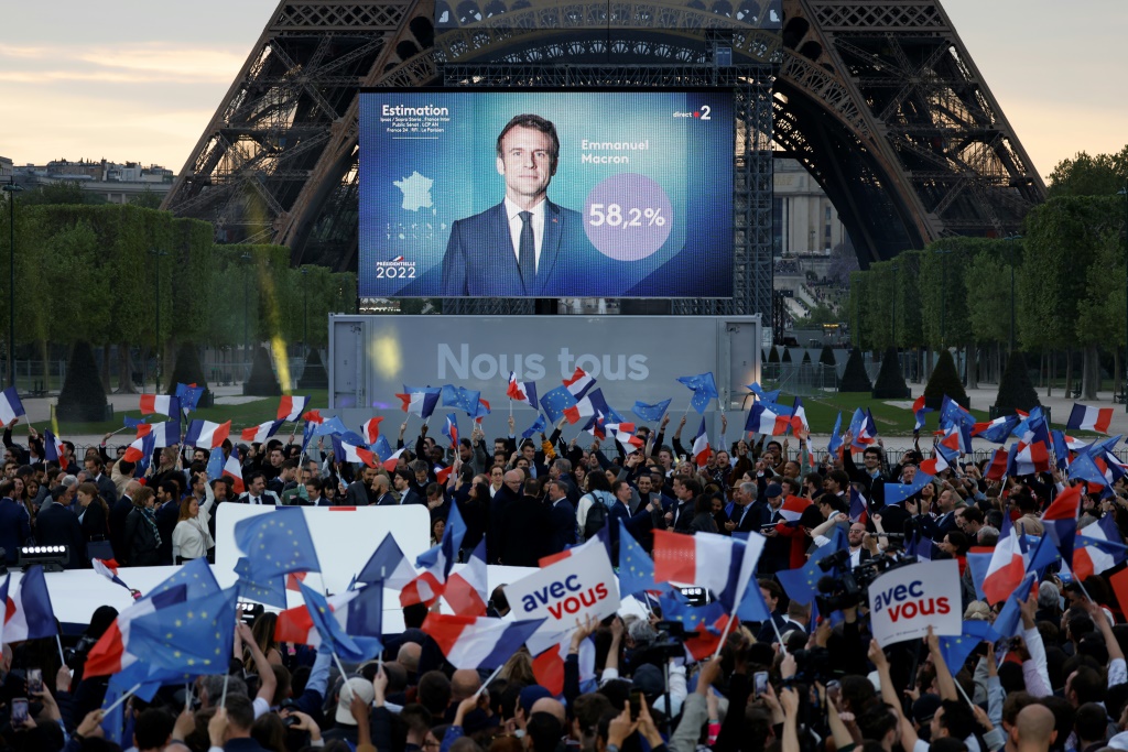 أنصار الرئيس الفرنسي إيمانويل ماكرون يحتفلون بعد صدور التقديرات الأولية لنتائج الانتخابات الرئاسية في حديقة "شان دو مارس" في باريس في 24 نيسان/أبريل 2022 (ا ف ب)