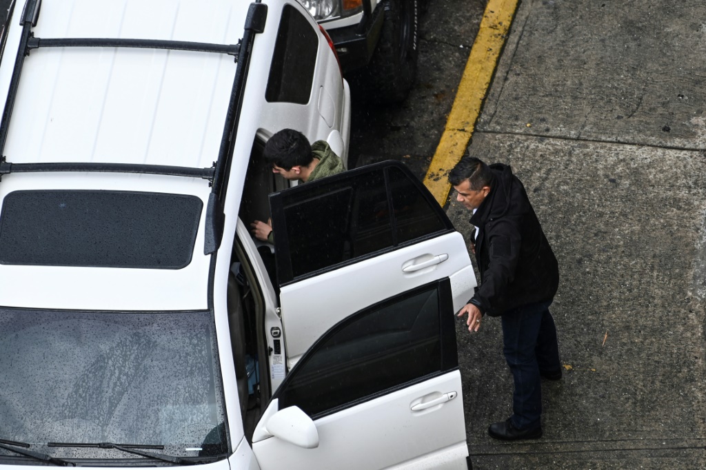 حارس شخصي يرافق رجلاً أثناء خروجه من سيارته امام مركز تسوق في كاراكاس في 20 نيسان/أبريل 2022 (ا ف ب)