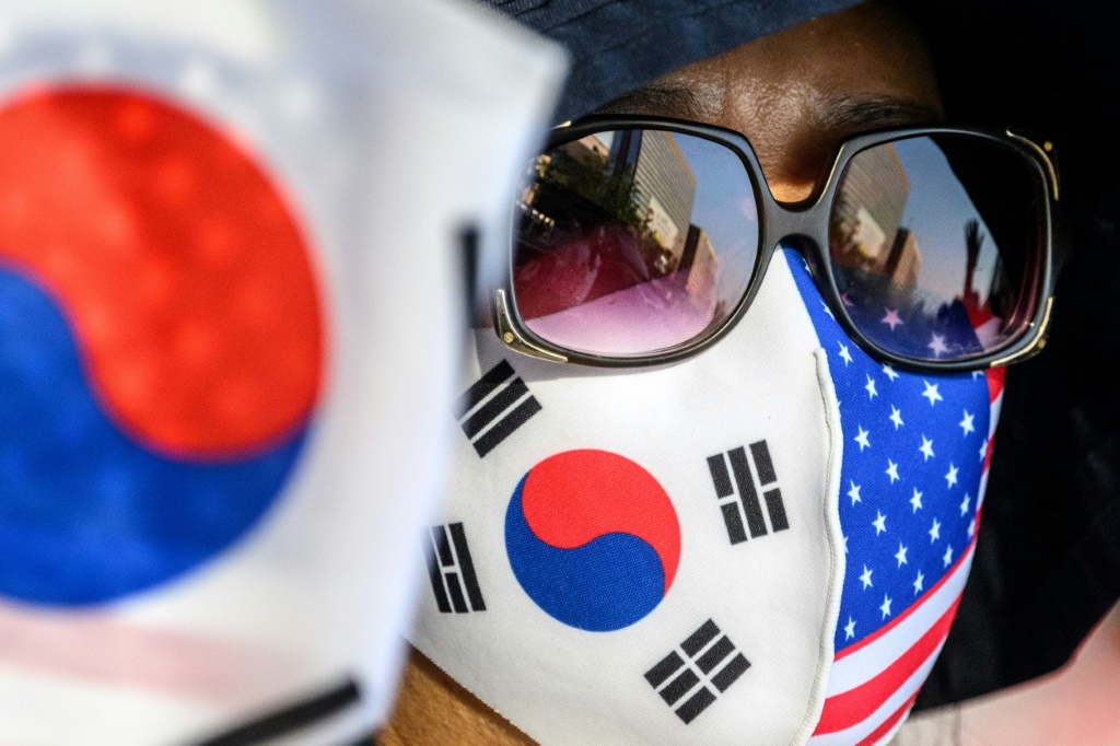 امرأة تضع كمامة عليها العلمين الكوري الجنوبي والأميركي أثناء تجمع ديني في سيول في 21 أيار/مايو 2022 أثناء زيارة الرئيس الأميركي جو بايدن (ا ف ب)