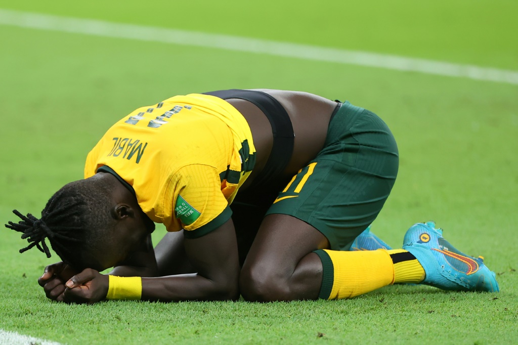 أوير مابيل يركع احتفالا بتأهل أستراليا الى نهائيات كأس العالم 2022 بعد فوزها في الملحق الدولي على البيرو على استاد أحمد بن علي في الدوحة في 13 حزيران/يونيو 2022 (ا ف ب)