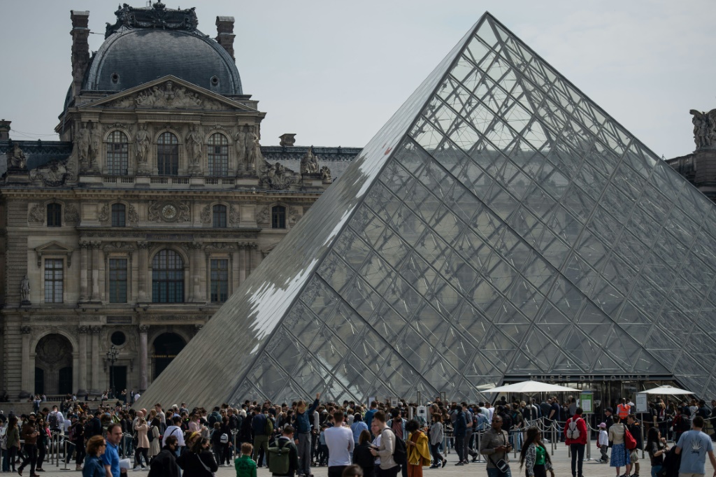 عدد من الزوار أمام متحف اللوفر في باريس في 29 نيسان/أبريل 2022 (اف ب)