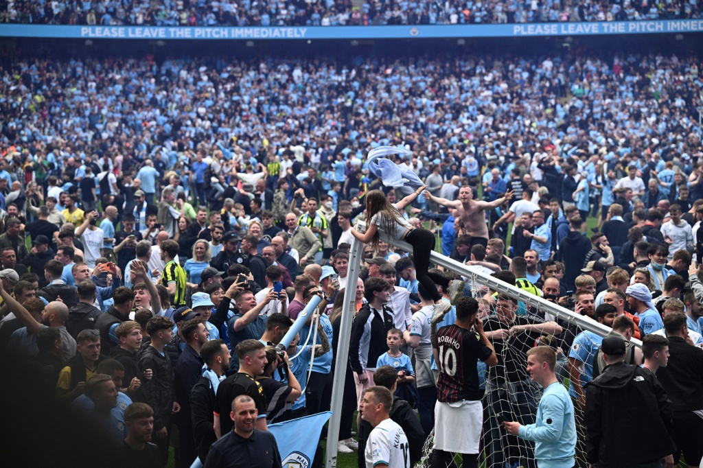 لقطة لانصار مانشستر سيتي الذين اجتاحوا ملعب الاتحاد للاحتفال باحتفاظ فريقهم بلقب بطل الدوري الانكليزي الممتازر لكرة القدم. 22 ايار/مايو 2022 (ا ف ب)