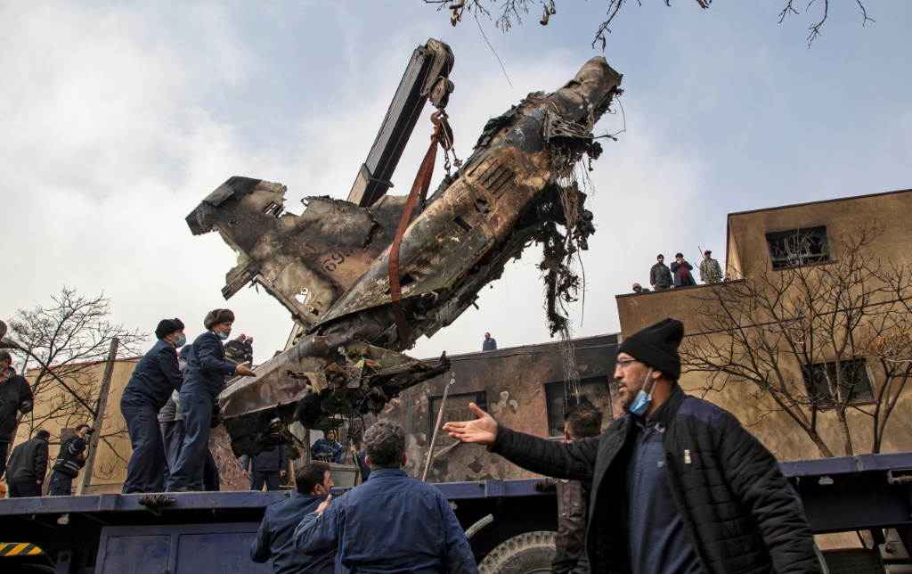حطام طائرة عسكرية إيرانية أثناء رفعه من مكان سقوطها في مدينة تبريز في 21 شباط/فبراير 2022. (ا ف ب) 