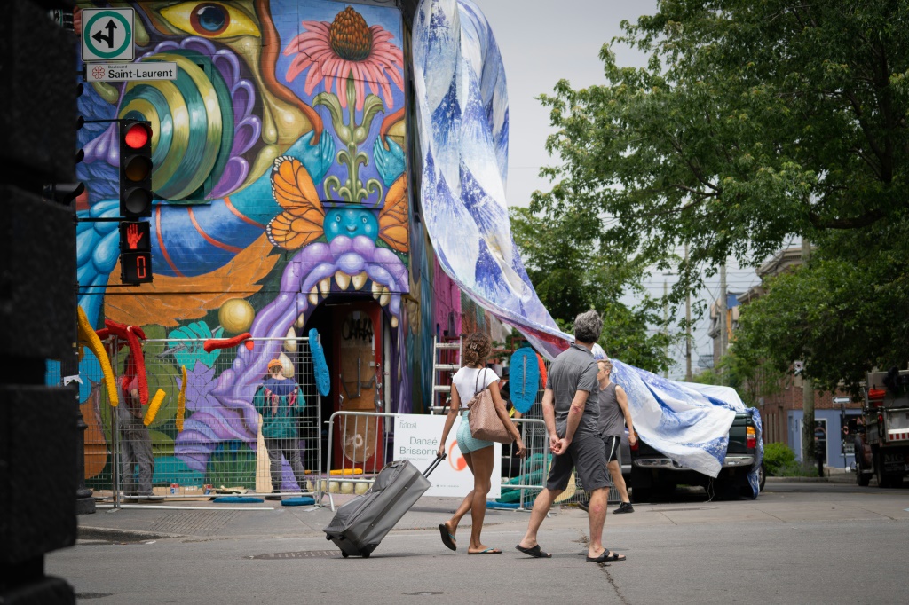 فنانون يرسمون لوحة جدارية في أحد شوارع مونتريال الكندية في 16 حزيران/يونيو 2022 (ا ف ب)